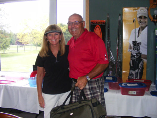 Connie Morrison of London presents the men's longest drive prize to Norm Gamble of Meaford.